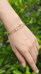 young woman wearing gold-plated hypoallergenic bracelet, showing their anti-tarnish shine suitable for sensitive skin and daily wear
