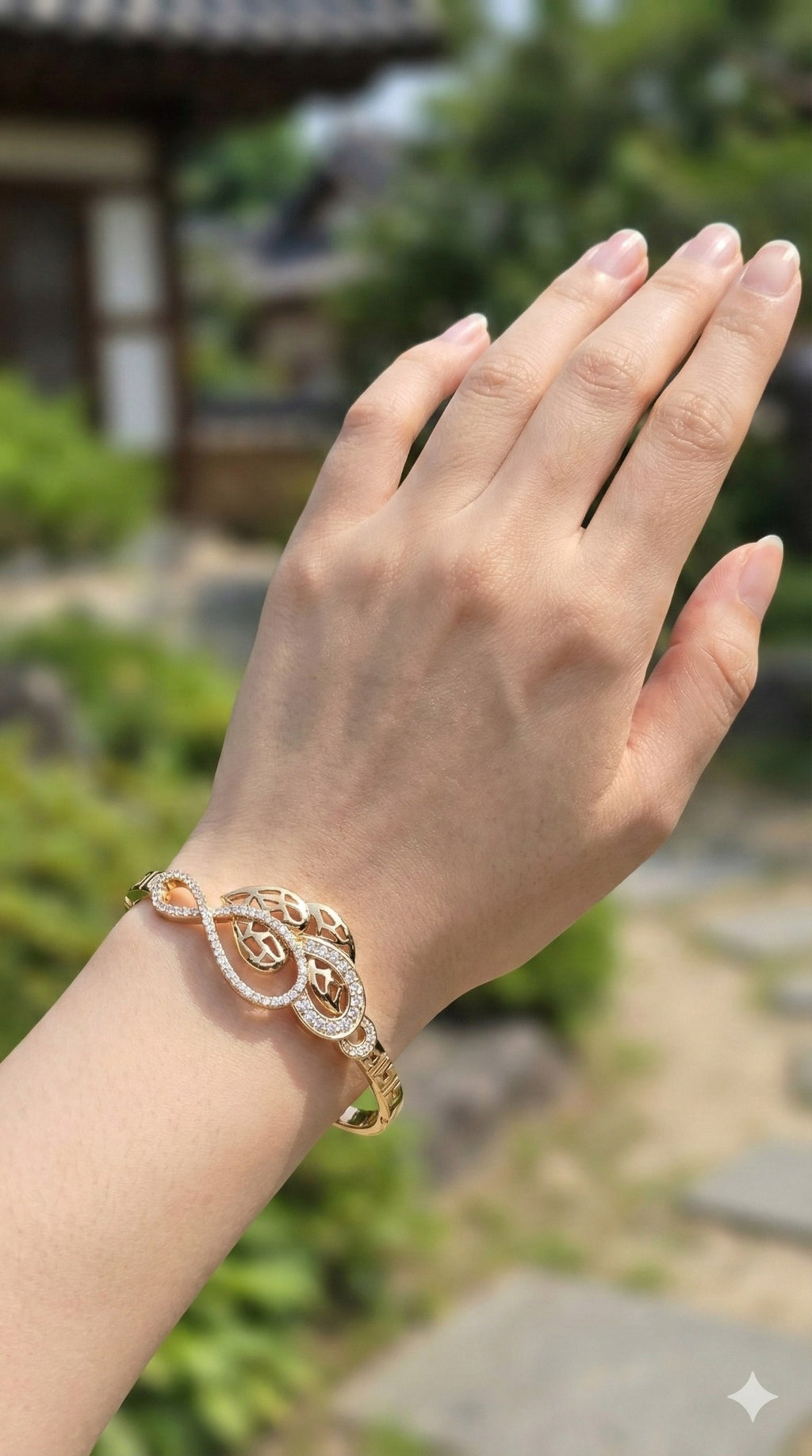 young woman wearing gold-plated hypoallergenic bracelet, showing their anti-tarnish shine suitable for sensitive skin and daily wear