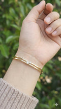 young woman wearing gold-plated hypoallergenic bracelet, showing their anti-tarnish shine suitable for sensitive skin and daily wear