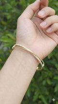 young woman wearing gold-plated hypoallergenic bracelet, showing their anti-tarnish shine suitable for sensitive skin and daily wear