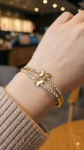 young woman wearing gold-plated hypoallergenic bracelet, showing their anti-tarnish shine suitable for sensitive skin and daily wear