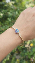 young woman wearing gold-plated hypoallergenic bracelet, showing their anti-tarnish shine suitable for sensitive skin and daily wear
