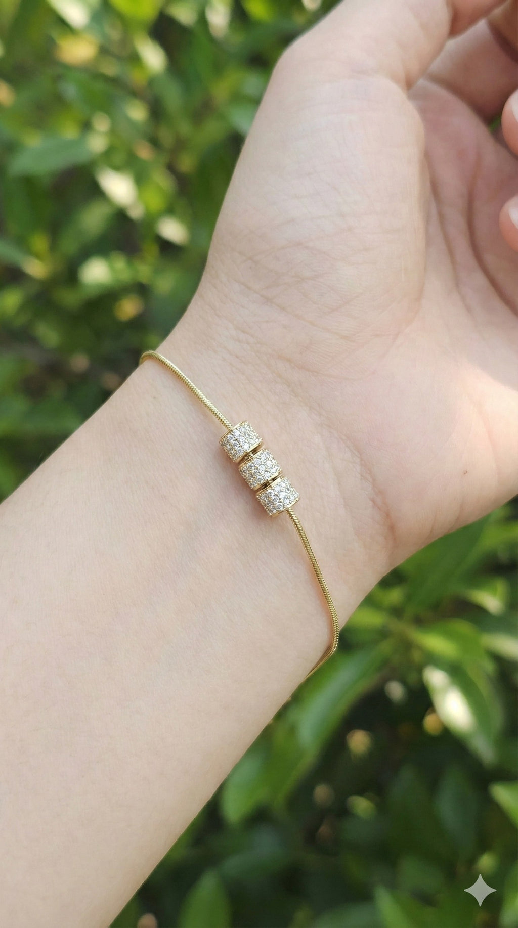 young woman wearing gold-plated hypoallergenic bracelet, showing their anti-tarnish shine suitable for sensitive skin and daily wear