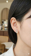 young woman wearing gold-plated hypoallergenic earrings, showing their anti-tarnish shine suitable for sensitive skin and daily wear