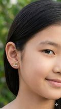 young woman wearing gold-plated hypoallergenic earrings, showing their anti-tarnish shine suitable for sensitive skin and daily wear