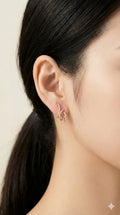 young woman wearing gold-plated hypoallergenic earrings, showing their anti-tarnish shine suitable for sensitive skin and daily wear