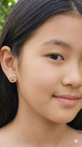 young woman wearing gold-plated hypoallergenic earrings, showing their anti-tarnish shine suitable for sensitive skin and daily wear