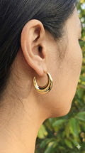 young woman wearing gold-plated hypoallergenic earrings, showing their anti-tarnish shine suitable for sensitive skin and daily wear