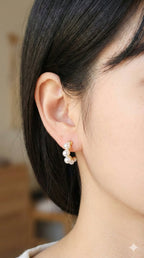 young woman wearing gold-plated hypoallergenic earrings, showing their anti-tarnish shine suitable for sensitive skin and daily wear
