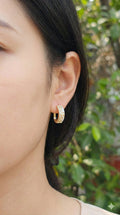 young woman wearing gold-plated hypoallergenic earrings, showing their anti-tarnish shine suitable for sensitive skin and daily wear