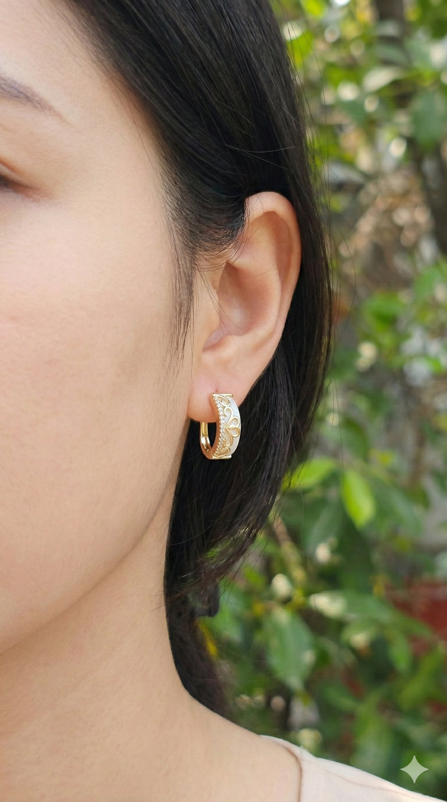 young woman wearing gold-plated hypoallergenic earrings, showing their anti-tarnish shine suitable for sensitive skin and daily wear