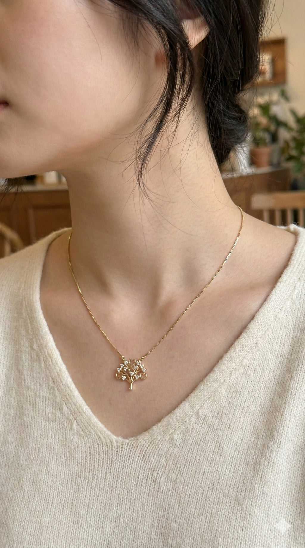 young woman wearing gold-plated hypoallergenic necklace, showing their anti-tarnish shine suitable for sensitive skin and daily wear