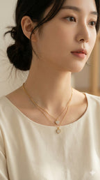 young woman wearing gold-plated hypoallergenic necklace, showing their anti-tarnish shine suitable for sensitive skin and daily wear